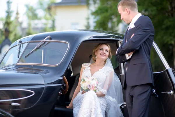 Matrimonio coppia si sta abbracciando vicino a una macchina — Foto Stock