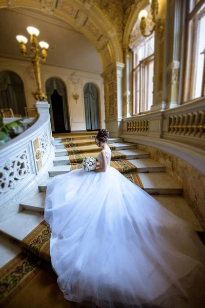 Schönheit Braut im Brautkleid mit Strauß und Spitzenschleier drinnen — Stockfoto