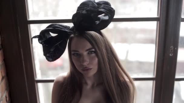 年轻美丽的模特在画室里摆着黑色蝴蝶结的头 — 图库视频影像