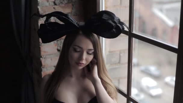 ランジェリー黒弓の頭の上のスタジオでポーズをとる若い美しいモデル — ストック動画