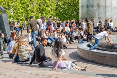Cabot Meydanı Canary Wharf'nda oturan insanlar ve sohbet ile dolu
