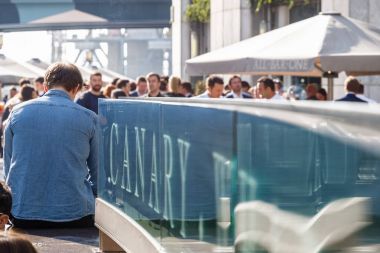 Bir liman içme kişilik bir kalabalık Canary Wharf işaretiyle 