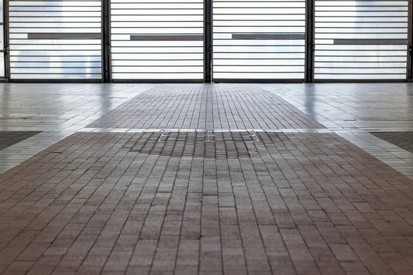 Tiled floor with backlit barred door — Stock Photo, Image