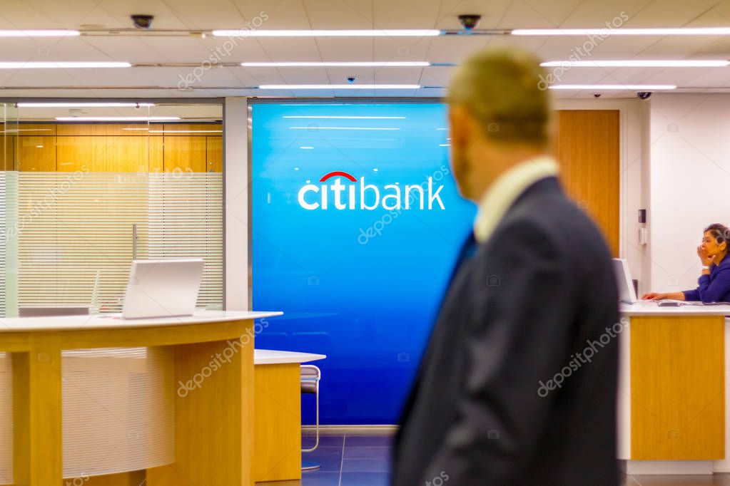 London, UK - May 15, 2017 - Citibank sign displayed at a branch in Canary Wharf with people passing by in the foreground