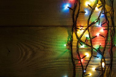 Işıklı ve bedava metin alanlı bir Noel arkaplanı. Noel ışıkları sınırda. Siyah arka planda parıldayan renkli Noel ışıkları. Yeni yıl. Noel zamanı. Dekorasyon. Çelenk.