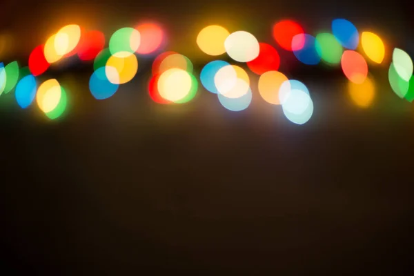 Bokeh świateł. Kolor światła na czarnym tle. Boże Narodzenie lub innych dekoracji, wianek oświetlenie bokeh. Streszczenie okrągłe światła bokeh tło uroczysty nowy rok, przystrojone drzewko bokeh. — Zdjęcie stockowe