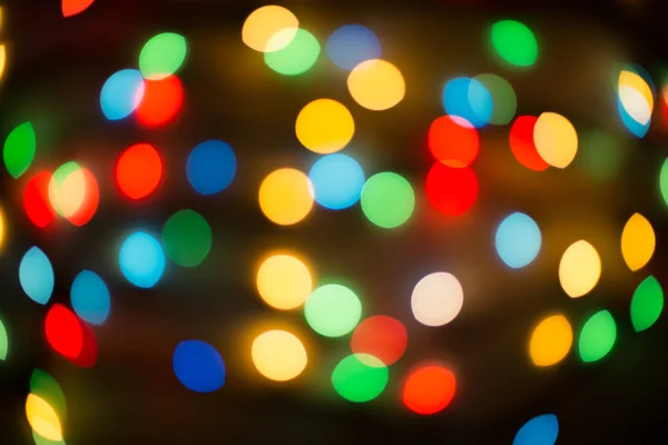 Bokeh-lampor. Färg ljus på svart bakgrund. Jul eller andra holiday dekorationer, krans belysning bokeh. Abstrakta cirkulära ljus bokeh nyår festliga bakgrund, dekorerade träd bokeh. — Stockfoto