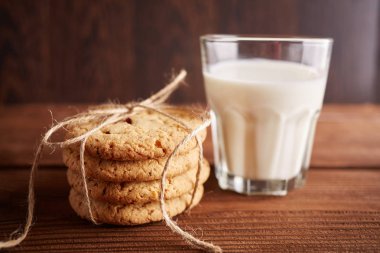 Kurabiye ve süt. Çikolatalı kurabiye ve bir bardak süt. Vintage bir görünüm. Lezzetli Kurabiye ve süt rustik ahşap zemin üzerinde. Gıda, abur cubur, yemek, pişirme ve kavramı yeme