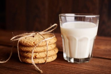 Kurabiye ve süt. Çikolatalı kurabiye ve bir bardak süt. Vintage bir görünüm. Lezzetli Kurabiye ve süt rustik ahşap zemin üzerinde. Gıda, abur cubur, yemek, pişirme ve kavramı yeme