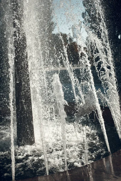 Jets of water in sunlight. Spray fountain. Splashes of water. Water drops. — Stock Photo, Image