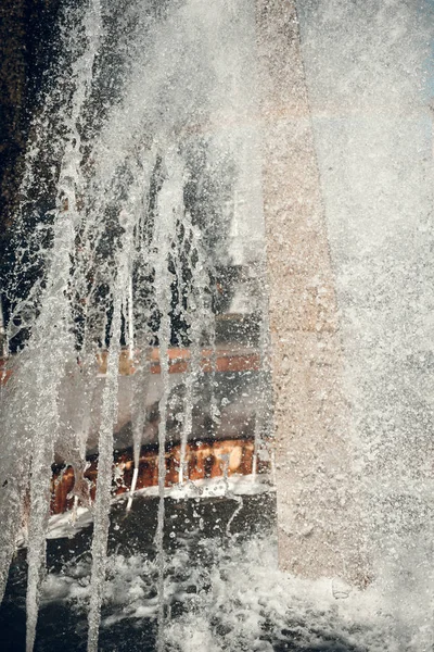 Jets of water in sunlight. Spray fountain. Splashes of water. Water drops.