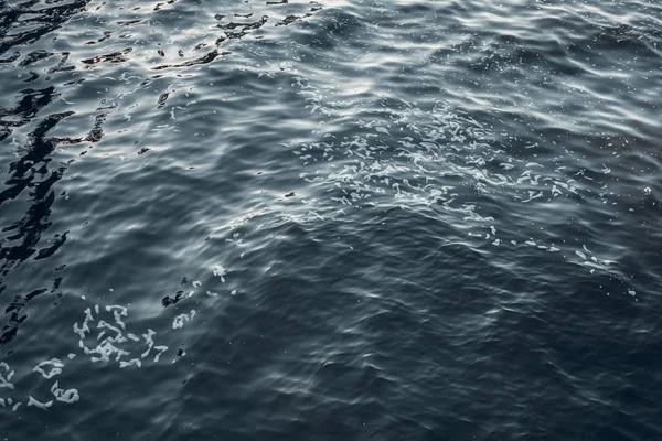 Vista aérea de la superficie del mar. Antecedentes de superficie de agua de mar clara. Agua de mar azul en calma. Textura marina. Fondo olas azules del mar con espuma de mar . — Foto de Stock