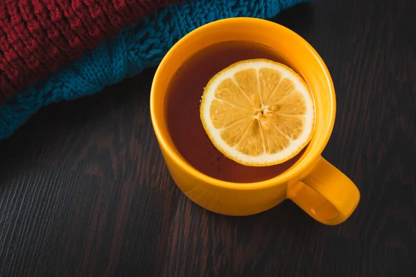 레몬과 뜨거운 차 한잔 입고 따뜻한 겨울 니트 스카프, 따뜻한 니트 스웨터 또는 담요. 스카프 및 레몬 차의 컵 아직도 인생. 겨울 시간입니다. 편안 하 고 부드러운 겨울 배경. — 스톡 사진