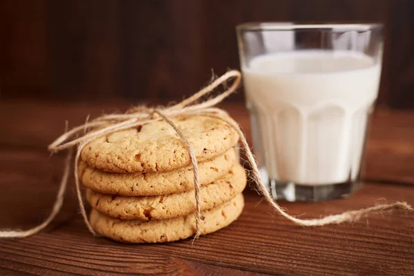 Kurabiye ve süt. Çikolatalı kurabiye ve bir bardak süt. Vintage bir görünüm. Lezzetli Kurabiye ve süt rustik ahşap zemin üzerinde. Gıda, abur cubur, yemek, pişirme ve kavramı yeme