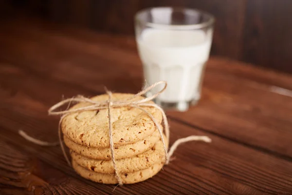 Cookies a mléko. Čokoláda čip cookies a sklenici mléka. Vintage vzhled. Chutné cookies a sklenice mléka na rustikální dřevěné pozadí. Jídlo, nezdravé jídlo, kulinářské, pečení a jíst koncept — Stock fotografie