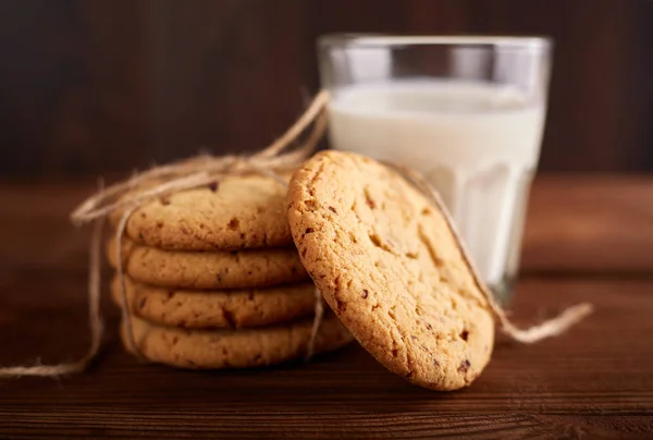 Cookies and milk. Chocolate chip cookies and a glass of milk. Vintage look. Tasty cookies and glass of milk on rustic wooden background. Food, junk-food, culinary, baking and eating concept — Stock Photo, Image
