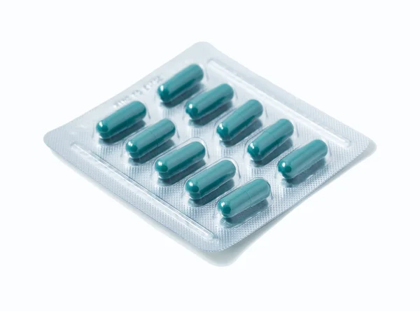 Embalagem blister de alumínio de comprimidos. As cápsulas são acondicionadas em blisters, isolados num fundo branco. Doença. Gripe. Medicamentos. — Fotografia de Stock