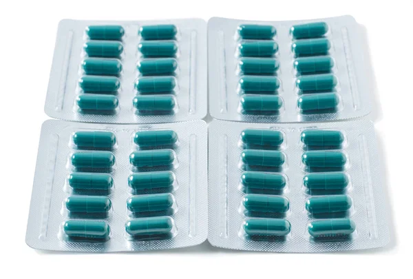 Envase de blister de aluminio con pastillas. Las cápsulas se envasan en blisters, aisladas sobre un fondo blanco. Enfermedad. Gripe. Medicamentos. — Foto de Stock