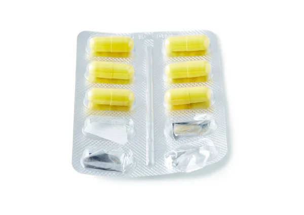 Aluminium blisterverpakking met pillen. De capsules zijn verpakt in blisterverpakkingen, geïsoleerd op een witte achtergrond. Ziekte. Griep. Geneesmiddelen. Stockafbeelding
