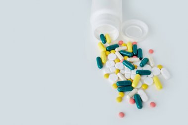 Blister tabletleri. Kapsüller beyaz bir arka plan üzerinde izole kabarcık içinde paketlenir. Hastalık. Grip. İlaçlar. Tablet bir şişe dışarı dökülür