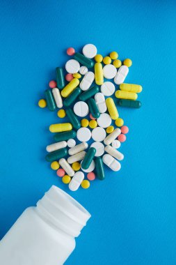 Blister tabletleri. Kapsüller beyaz bir arka plan üzerinde izole kabarcık içinde paketlenir. Hastalık. Grip. İlaçlar. Tablet bir şişe dışarı dökülür