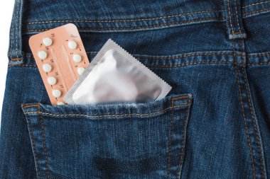 Prezervatif'kot pantolon pakette. Güvenli seks kavramı. Sağlık Tıp, doğum kontrolü ve doğum kontrol hapı. Oral kontraseptif hap kadar yakın. İstenmeyen gebelik karşı koruma. AIDS'e karşı koruma