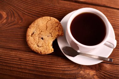 Kahve ve çikolata ile ev yapımı kurabiyeler. El yapımı çikolata kurabiye ve fincan espresso ahşap masa üzerinde. Lezzetli parçacıklı kurabiye yığını. Noel kurabiyeleri. Bisküvi. Yulaf bisküvi.