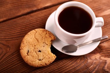 Kahve ve çikolata ile ev yapımı kurabiyeler. El yapımı çikolata kurabiye ve fincan espresso ahşap masa üzerinde. Lezzetli parçacıklı kurabiye yığını. Noel kurabiyeleri. Bisküvi. Yulaf bisküvi.