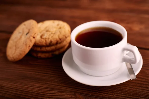 Coffee and Homemade cookies with chocolate. Handmade Chocolate cookies and cup of espresso on wooden table. Pile of delicious chip cookies. Christmas cookies. Biscuits. Oat biscuits.