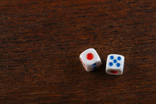 Rolling two dice on a wooden desk. Gambling dices falling. Dices set to play backgammon. Back gammon table game. Play this ancient Turkish and Persian table game with strategy and luck.