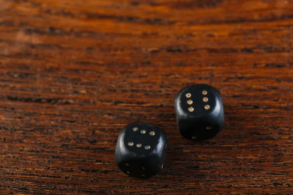 Rolling two dice on a wooden desk. Gambling dices falling. Dices set to play backgammon. Back gammon table game. Play this ancient Turkish and Persian table game with strategy and luck.