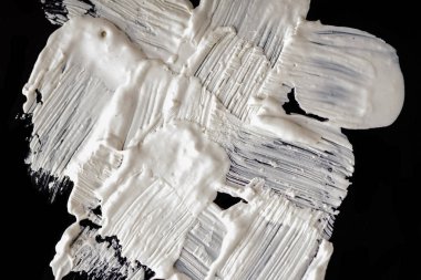 Yapısal Alçı beyaz siyah bir arka plan. Beyaz krema. boya karalama. Hamuru.