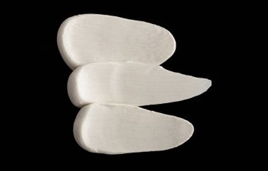 Yapısal Alçı beyaz siyah bir arka plan. Beyaz krema. boya karalama. Hamuru.