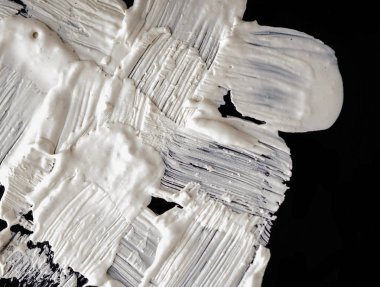 Yapısal Alçı beyaz siyah bir arka plan. Beyaz krema. boya karalama. Hamuru.