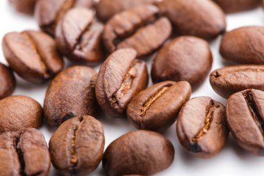 Kavrulmuş kahvenin beyaz arka planda izole. Kavrulmuş kahve çekirdekleri arka plan kapatın. Üst metin için kopya yer beyaz zemin üzerine kahve çekirdekleri kazık. Günaydın.