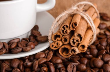 Kahve çekirdekleri ve tarçın çuval bezi bir arka plan üzerinde. Kavrulmuş kahve çekirdekleri arka plan kapatın. Üst metin kopyalama yeri olan kahve çekirdekleri kazık. Baharat. Baharat. Tarçın. Badian. Kahve evi.