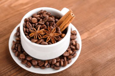 Kahve çekirdekleri ve tarçın çuval bezi bir arka plan üzerinde. Kavrulmuş kahve çekirdekleri arka plan kapatın. Üst metin kopyalama yeri olan kahve çekirdekleri kazık. Baharat. Baharat. Tarçın. Badian. Kahve evi.