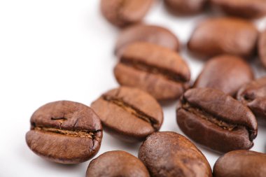 Kavrulmuş kahvenin beyaz arka planda izole. Kavrulmuş kahve çekirdekleri arka plan kapatın. Üst metin için kopya yer beyaz zemin üzerine kahve çekirdekleri kazık. Günaydın.