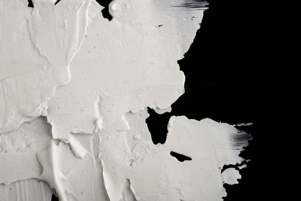 Structural plaster white on a black background. White Cream. paint smear. Plasticine.