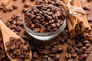 Kahve çekirdekleri ve tarçın çuval bezi bir arka plan üzerinde. Kavrulmuş kahve çekirdekleri arka plan kapatın. Üst metin kopyalama yeri olan kahve çekirdekleri kazık. Baharat. Baharat. Tarçın. Badian. Kahve evi.
