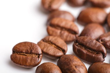 Kavrulmuş kahvenin beyaz arka planda izole. Kavrulmuş kahve çekirdekleri arka plan kapatın. Üst metin için kopya yer beyaz zemin üzerine kahve çekirdekleri kazık. Günaydın.