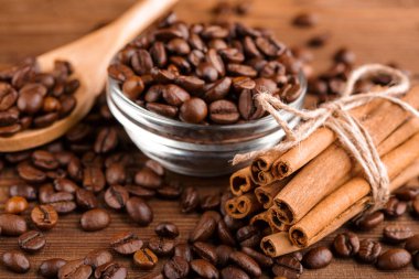Kahve çekirdekleri ve tarçın çuval bezi bir arka plan üzerinde. Kavrulmuş kahve çekirdekleri arka plan kapatın. Üst metin kopyalama yeri olan kahve çekirdekleri kazık. Baharat. Baharat. Tarçın. Badian. Kahve evi.