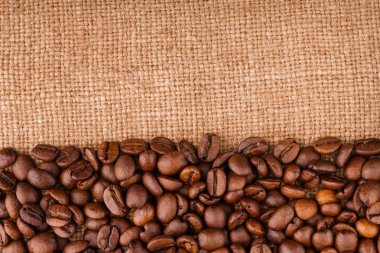 kahve çekirdekleri çuval bezi arka plan üzerinde. kavrulmuş kahvenin beyaz arka planda izole. Kavrulmuş kahve çekirdekleri arka plan kapatın. Kahve çekirdekleri kazık kopya alanı metin için beyaz zemin üzerine üstten