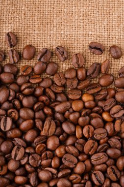 kahve çekirdekleri çuval bezi arka plan üzerinde. kavrulmuş kahvenin beyaz arka planda izole. Kavrulmuş kahve çekirdekleri arka plan kapatın. Kahve çekirdekleri kazık kopya alanı metin için beyaz zemin üzerine üstten