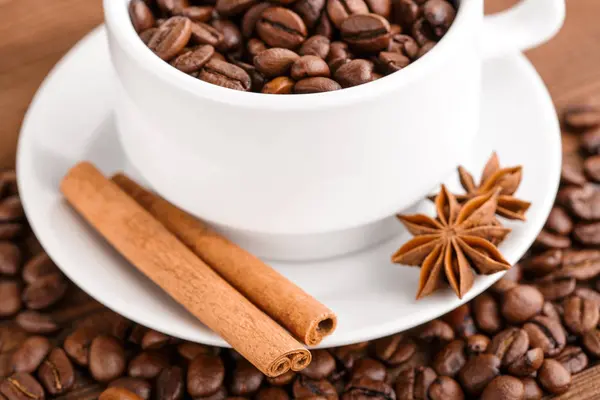 Kahve çekirdekleri ve tarçın çuval bezi bir arka plan üzerinde. Kavrulmuş kahve çekirdekleri arka plan kapatın. Üst metin kopyalama yeri olan kahve çekirdekleri kazık. Baharat. Baharat. Tarçın. Badian. Kahve evi.