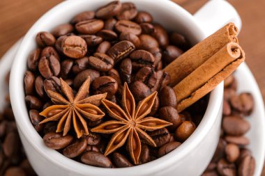 Kahve çekirdekleri ve tarçın çuval bezi bir arka plan üzerinde. Kavrulmuş kahve çekirdekleri arka plan kapatın. Üst metin kopyalama yeri olan kahve çekirdekleri kazık. Baharat. Baharat. Tarçın. Badian. Kahve evi.