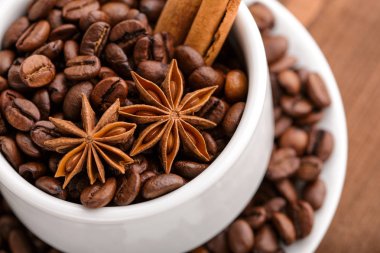 Kahve çekirdekleri ve tarçın çuval bezi bir arka plan üzerinde. Kavrulmuş kahve çekirdekleri arka plan kapatın. Üst metin kopyalama yeri olan kahve çekirdekleri kazık. Baharat. Baharat. Tarçın. Badian. Kahve evi.