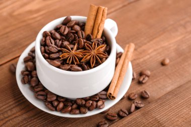 Kahve çekirdekleri ve tarçın çuval bezi bir arka plan üzerinde. Kavrulmuş kahve çekirdekleri arka plan kapatın. Üst metin kopyalama yeri olan kahve çekirdekleri kazık. Baharat. Baharat. Tarçın. Badian. Kahve evi.