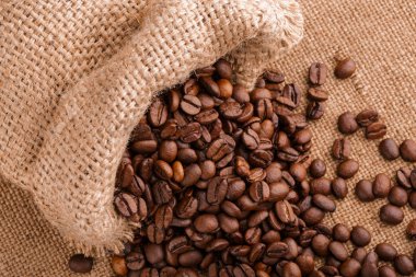kahve çekirdekleri çuval bezi arka plan üzerinde. kavrulmuş kahvenin beyaz arka planda izole. Kavrulmuş kahve çekirdekleri arka plan kapatın. Kahve çekirdekleri kazık kopya alanı metin için beyaz zemin üzerine üstten