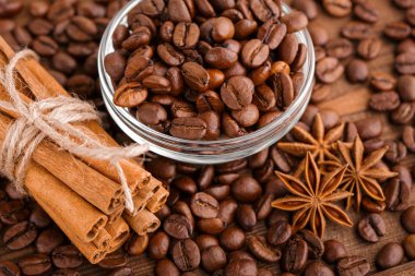 Kahve çekirdekleri ve tarçın çuval bezi bir arka plan üzerinde. Kavrulmuş kahve çekirdekleri arka plan kapatın. Üst metin kopyalama yeri olan kahve çekirdekleri kazık. Baharat. Baharat. Tarçın. Badian. Kahve evi.